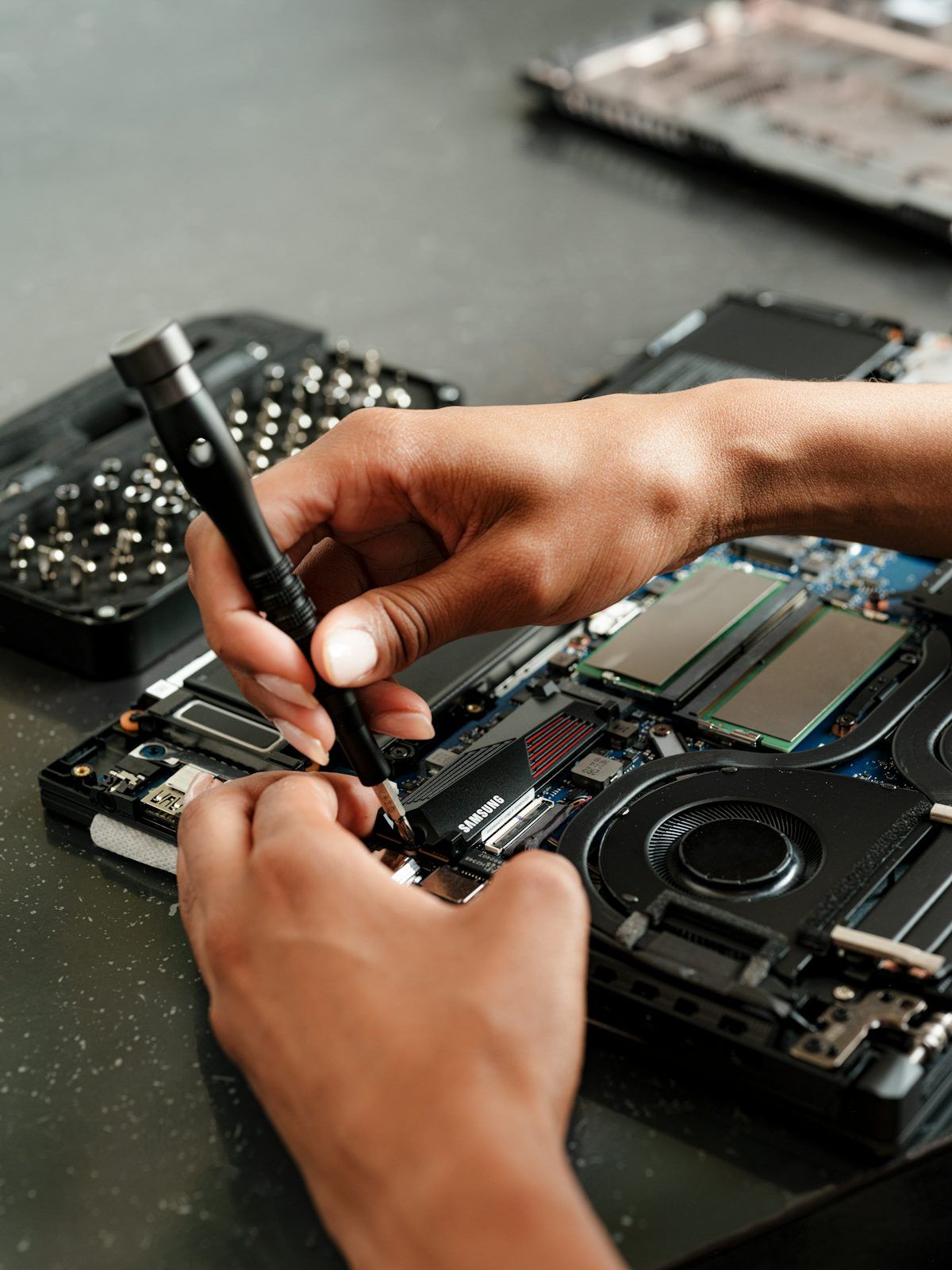 Technik sprawdzający laptopa poleasingowego podczas kontroli jakości — weryfikacja stanu baterii, obudowy i podzespołów